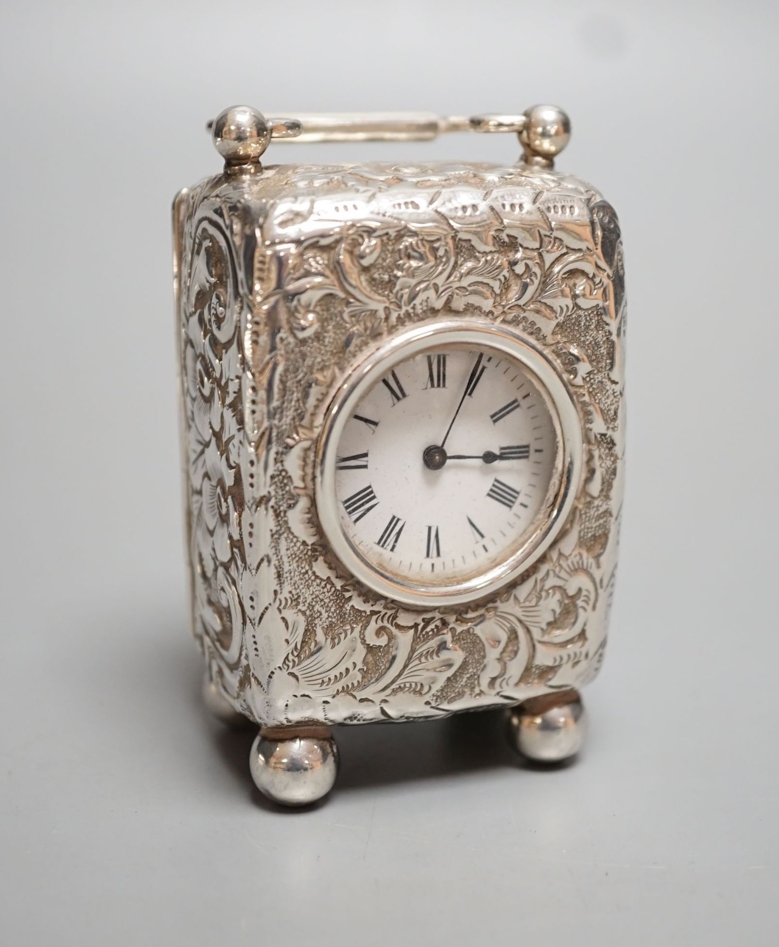 A late Victorian embossed silver cased miniature carriage timepiece, maker G.B, London, 1894, on bun feet, height 78mm.